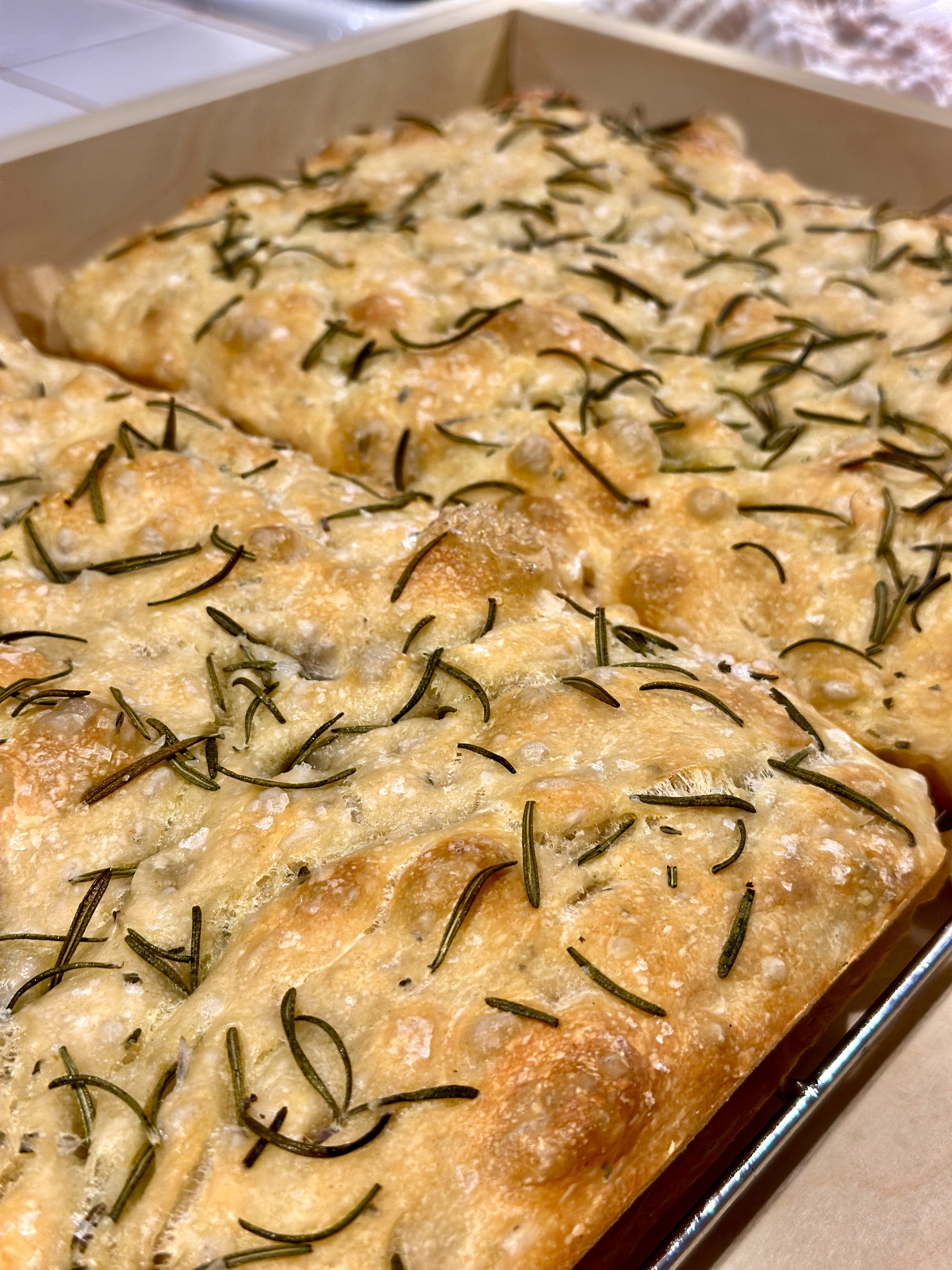 Freshly baked herb focaccia in a sheet